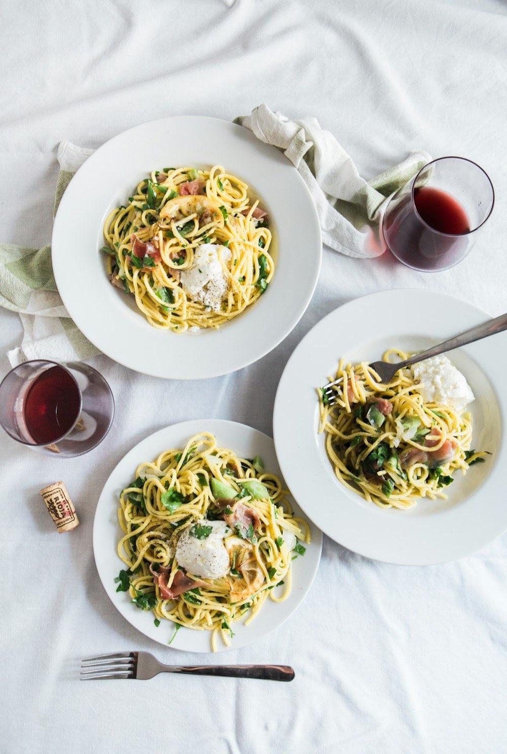 手打ちパスタと赤ワインが並ぶテーブルの俯瞰。Trattoria Luceのおすすめ料理